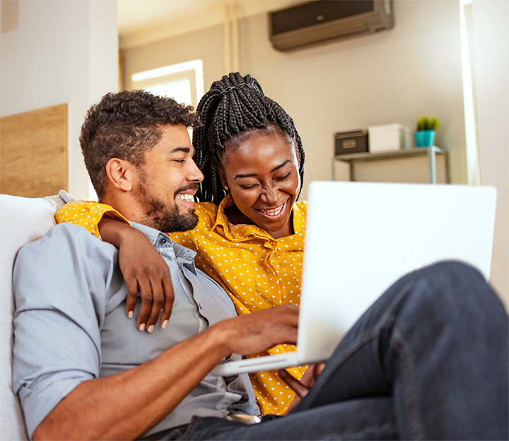 Happy couple using laptop
